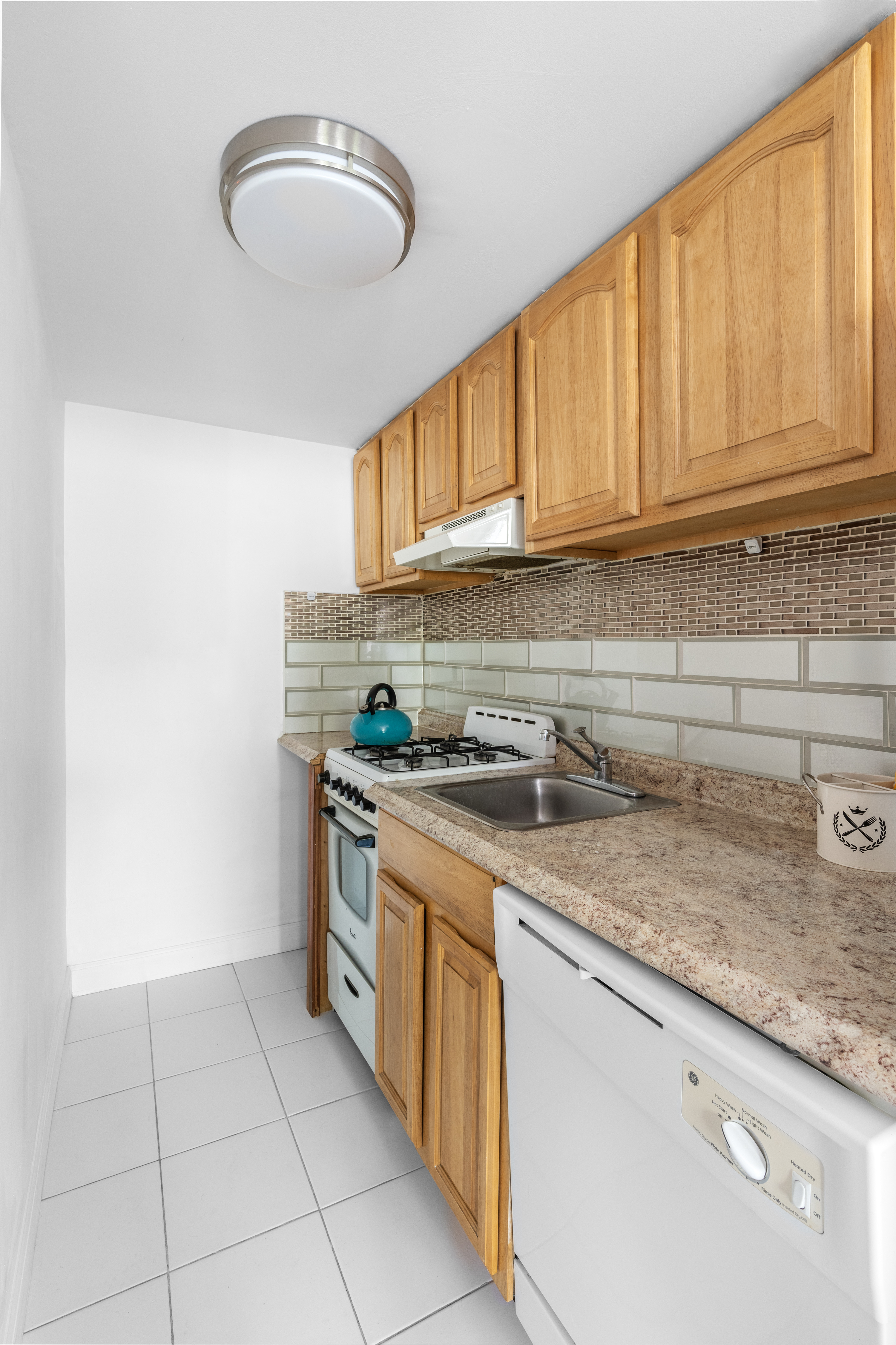 323 East 116th Street, Unit 3F Manhattan, NY 10035 - Photo 3 of 6 a kitchen with stainless steel appliances granite countertop a sink stove and cabinets