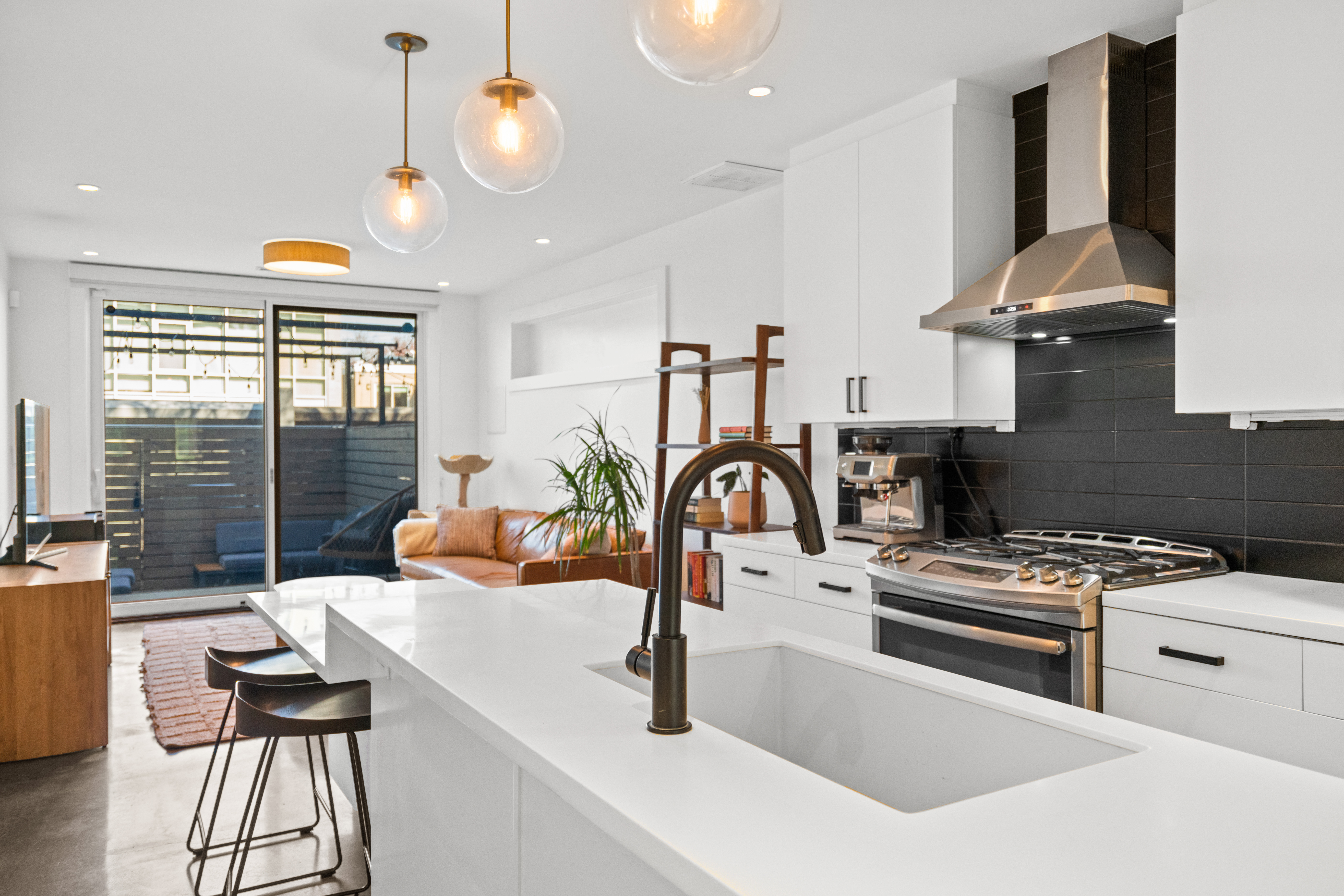 a kitchen with stainless steel appliances a sink a stove and a wooden floor