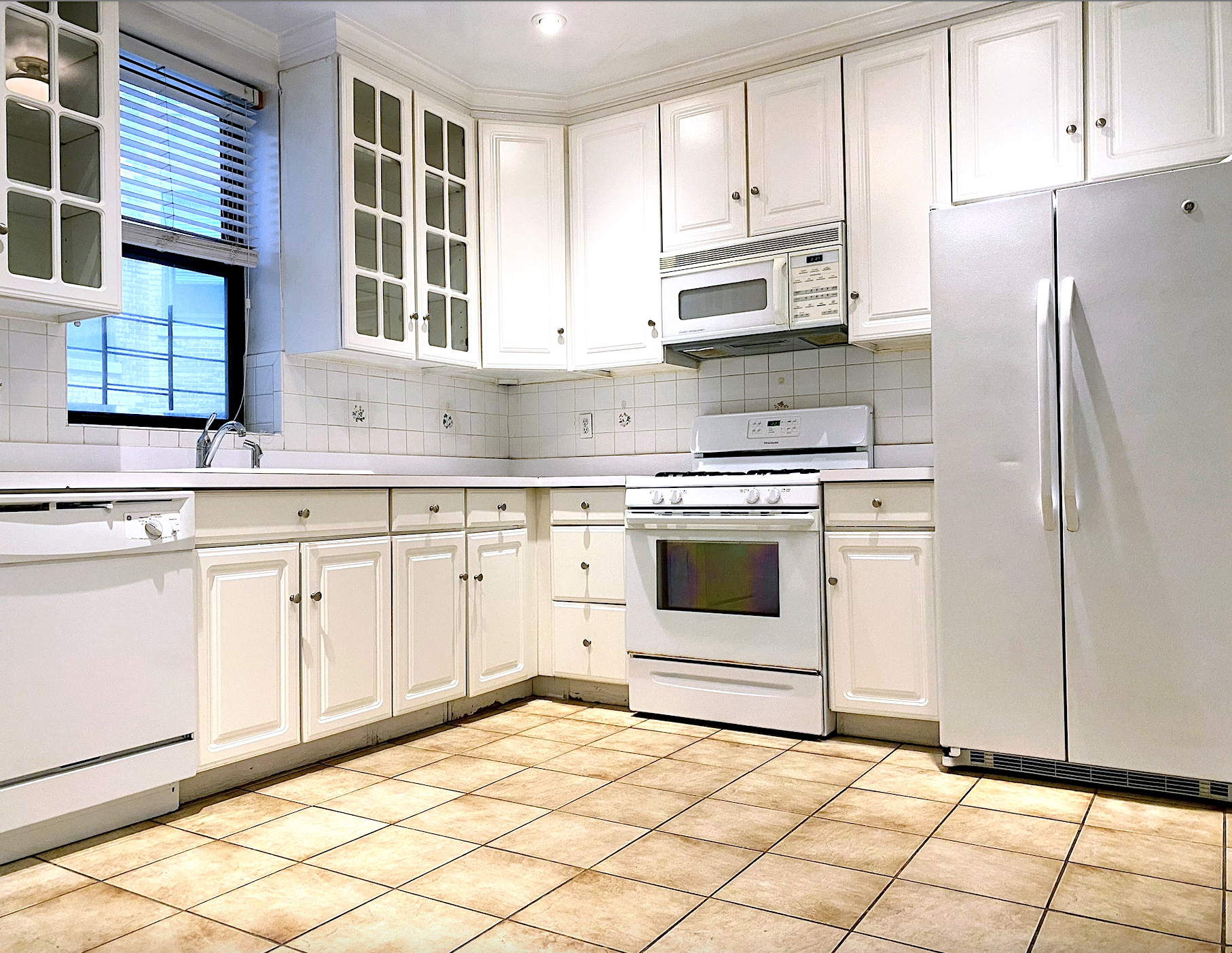 a kitchen with white cabinets and white appliances