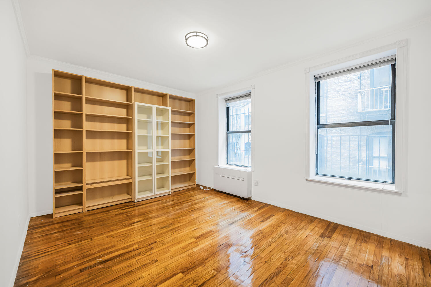 4 West 109th Street, Unit 4F Manhattan, NY 10025 - Photo 9 of 16 a view of an empty room with a window and wooden floor