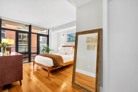 a bedroom with a bed and wooden floor