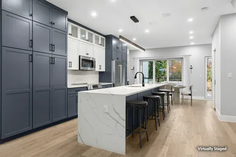 a kitchen with kitchen island a counter top space a sink stainless steel appliances and cabinets