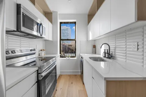 a kitchen with stainless steel appliances a sink stove and cabinets