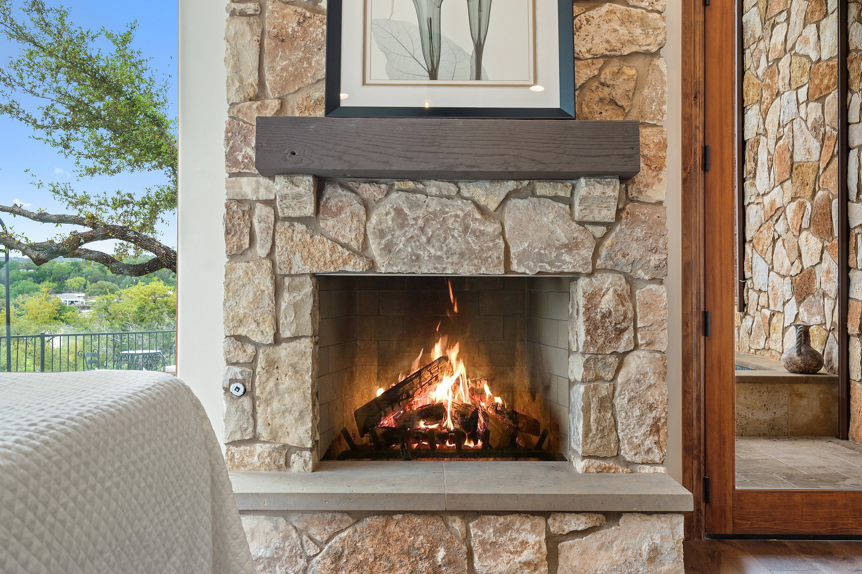 808 Rivercliff Drive Spicewood, TX 78669 - Photo 38 of 71 a living room with a fireplace and a floor to ceiling window