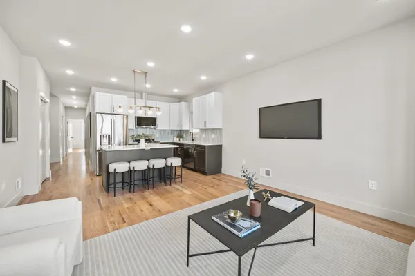 a living room with stainless steel appliances kitchen island granite countertop furniture and a view of kitchen