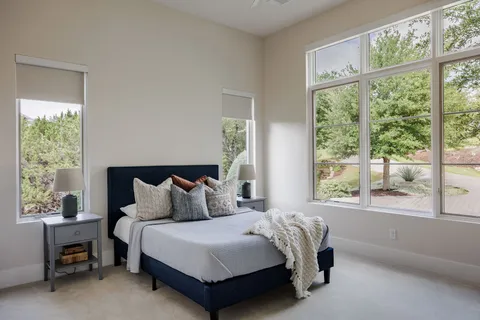 a bedroom with a bed and a large window