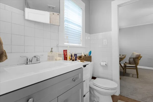 a bathroom with a sink toilet and window