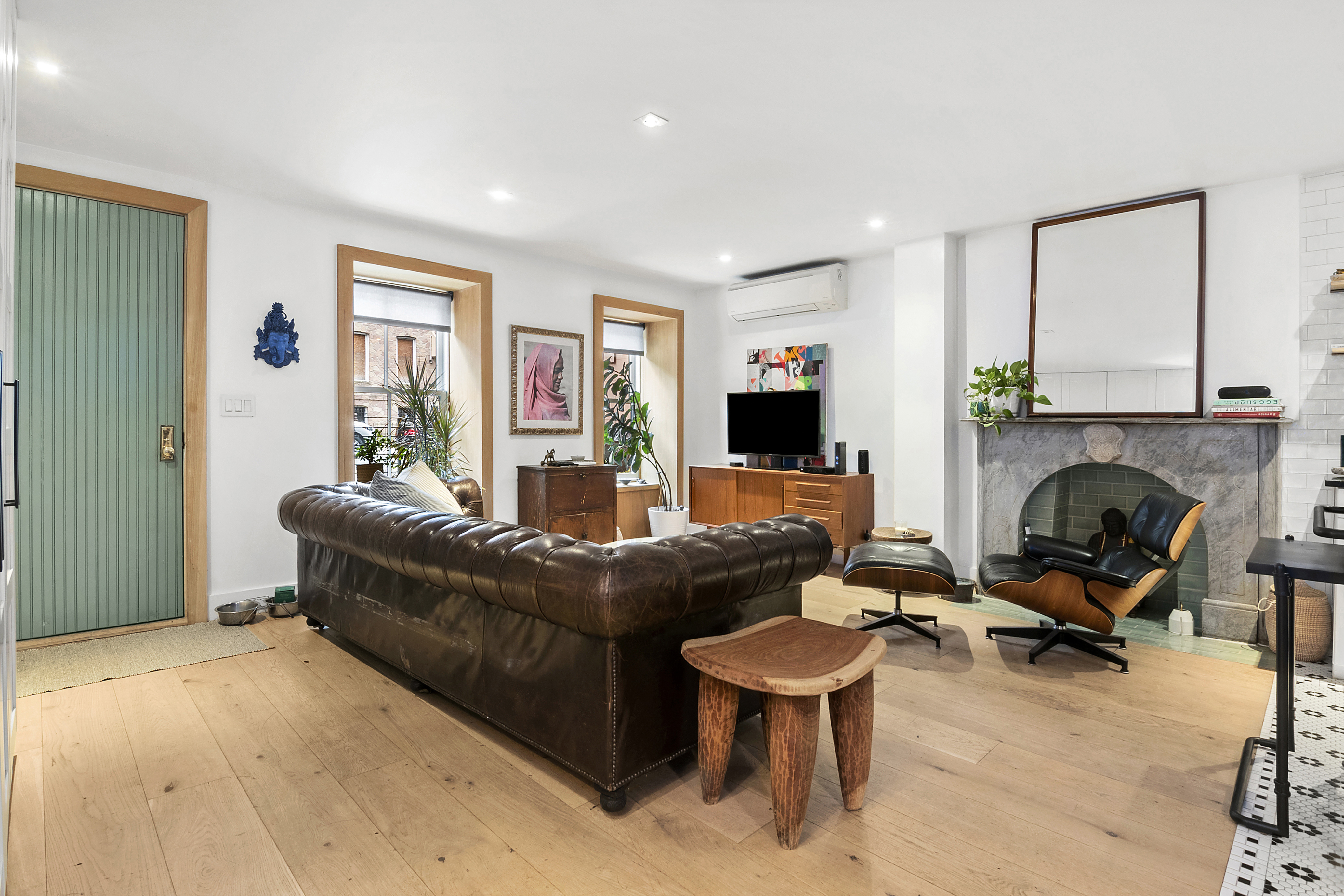 87 Monroe Street Brooklyn, NY 11216 - Photo 15 of 26 a living room with furniture flat screen tv and a fireplace