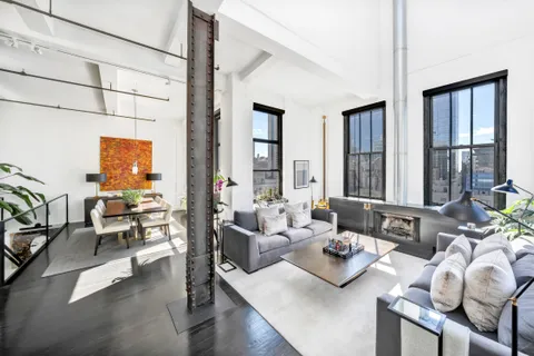 a living room with furniture and floor to ceiling windows