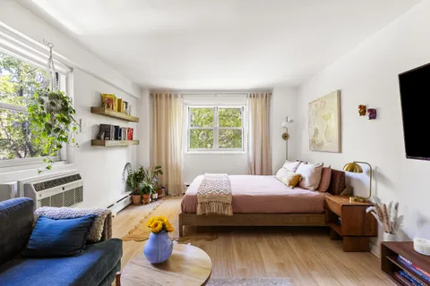 a bedroom with furniture and a flat screen tv