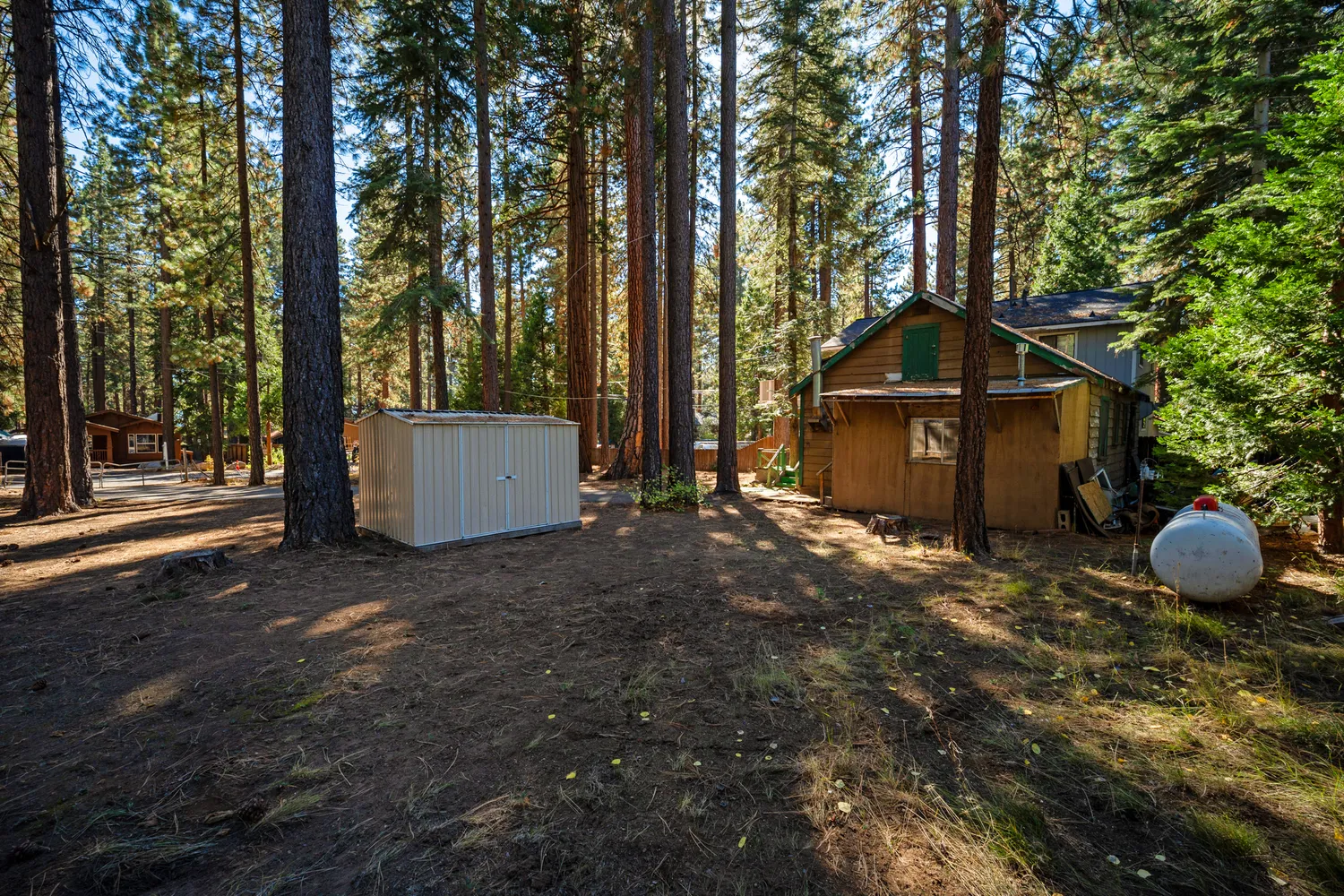 a view of a yard with chairs and wooden fence