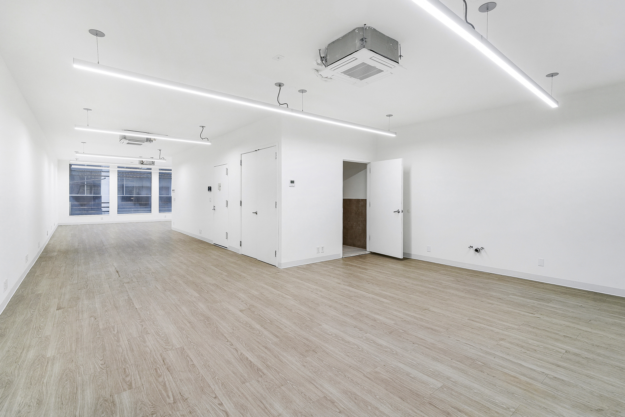 24 Beaver Street Manhattan, NY 10004 - Photo 13 of 25 an empty room with wooden floor and windows
