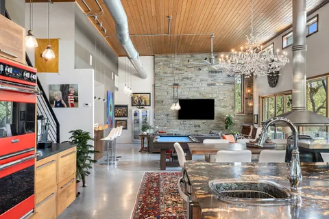 a kitchen with stainless steel appliances granite countertop a sink and a large window
