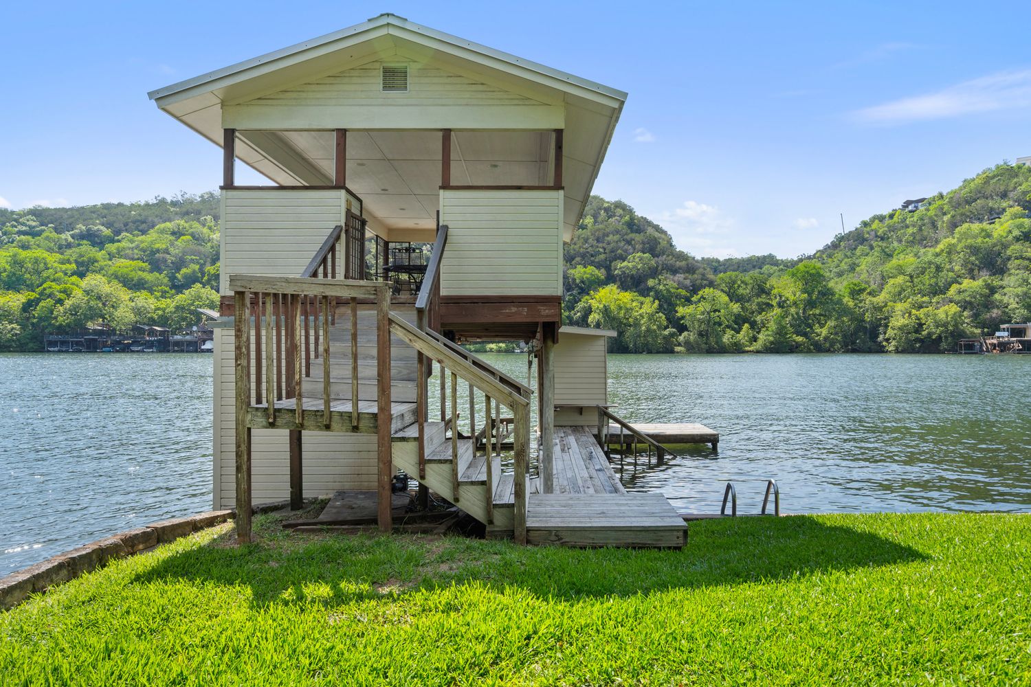 a view of a house with a yard from a lake view