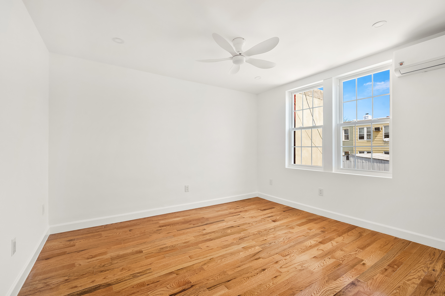 50-35 46th Street, Unit 2 Queens, NY 11377 - Photo 5 of 7 wooden floor in an empty room with a window