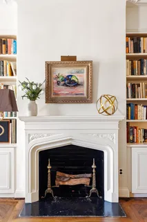 a living room with a fireplace and a book shelf