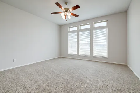 an empty room with a window and a fan