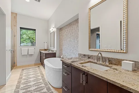 a bathroom with a granite countertop sink a toilet a mirror and shower