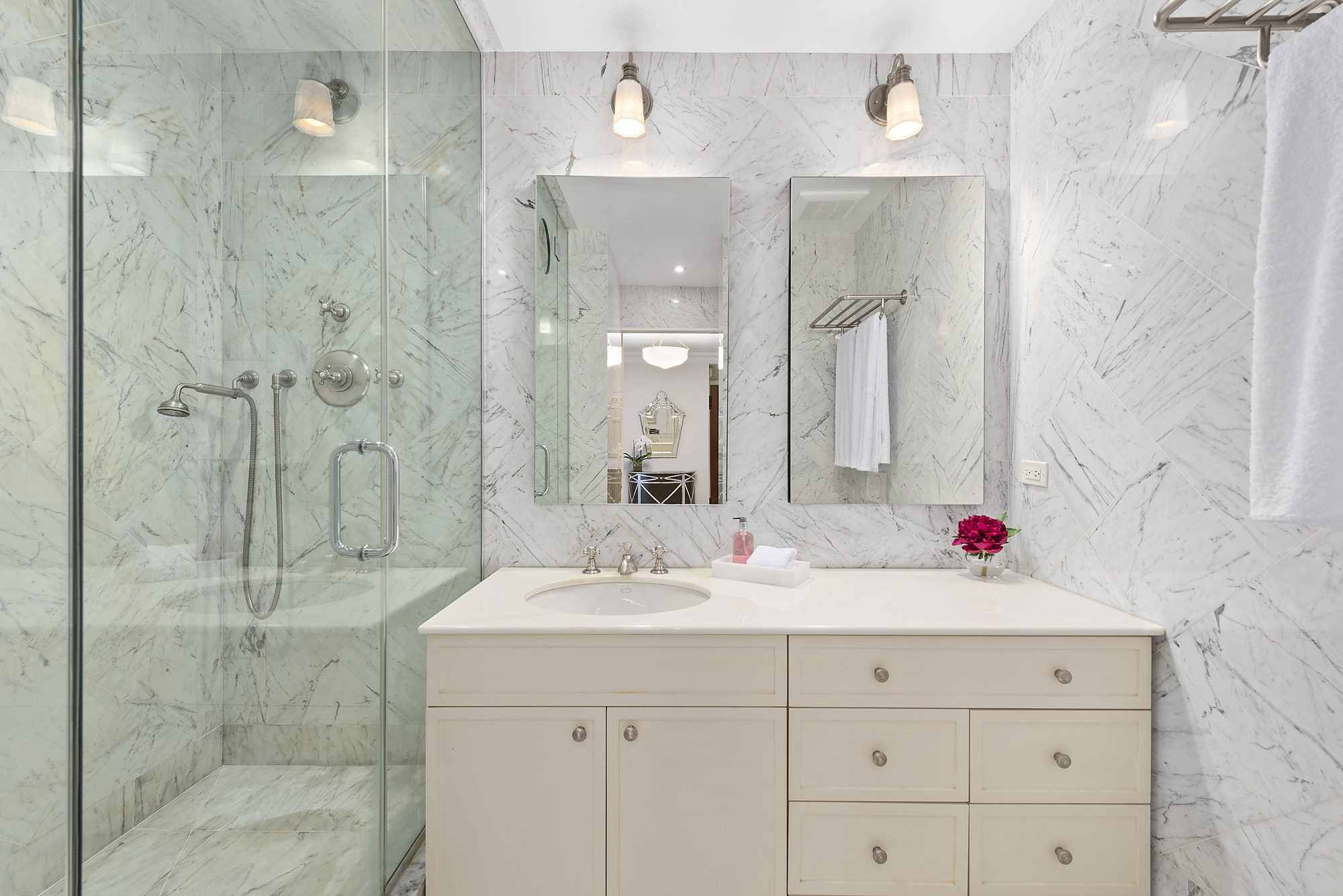 165 East 72nd Street, Unit 3L Manhattan, NY 10021 - Photo 7 of 13 a bathroom with a sink shower and a mirror