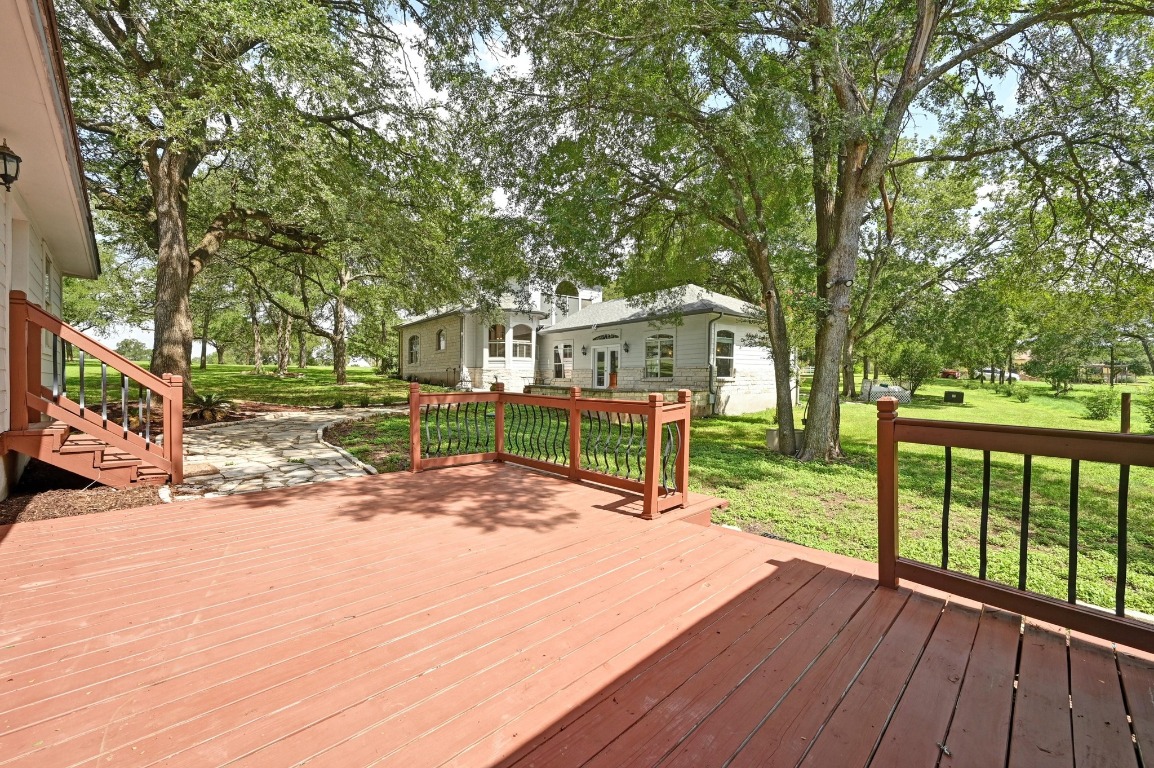 111 Trinity Street Cedar Creek, TX 78612 - Photo 26 of 38 a view of a house with a yard and wooden deck