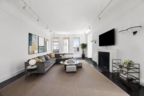 a living room with furniture a fireplace and a flat screen tv