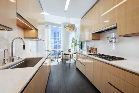 a kitchen with stainless steel appliances a stove a sink a cabinets and wooden floor