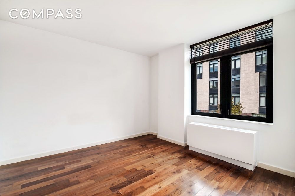 125 North 5th Street, Unit 2A Brooklyn, NY 11249 - Photo 3 of 10 a view of an empty room with wooden floor and a window