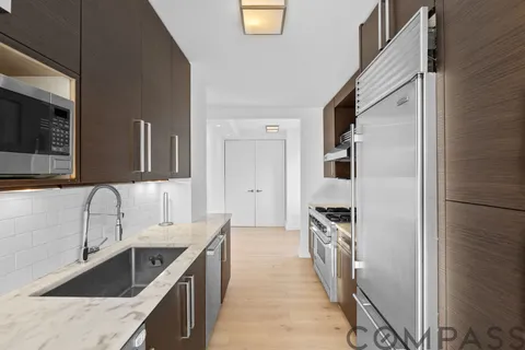 a kitchen with granite countertop stainless steel appliances a sink and a refrigerator