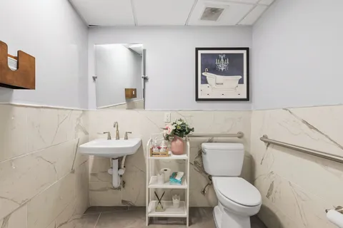 a bathroom with a toilet sink and mirror
