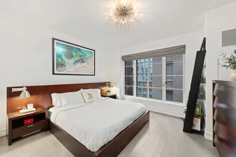 a bedroom with a bed and a large window