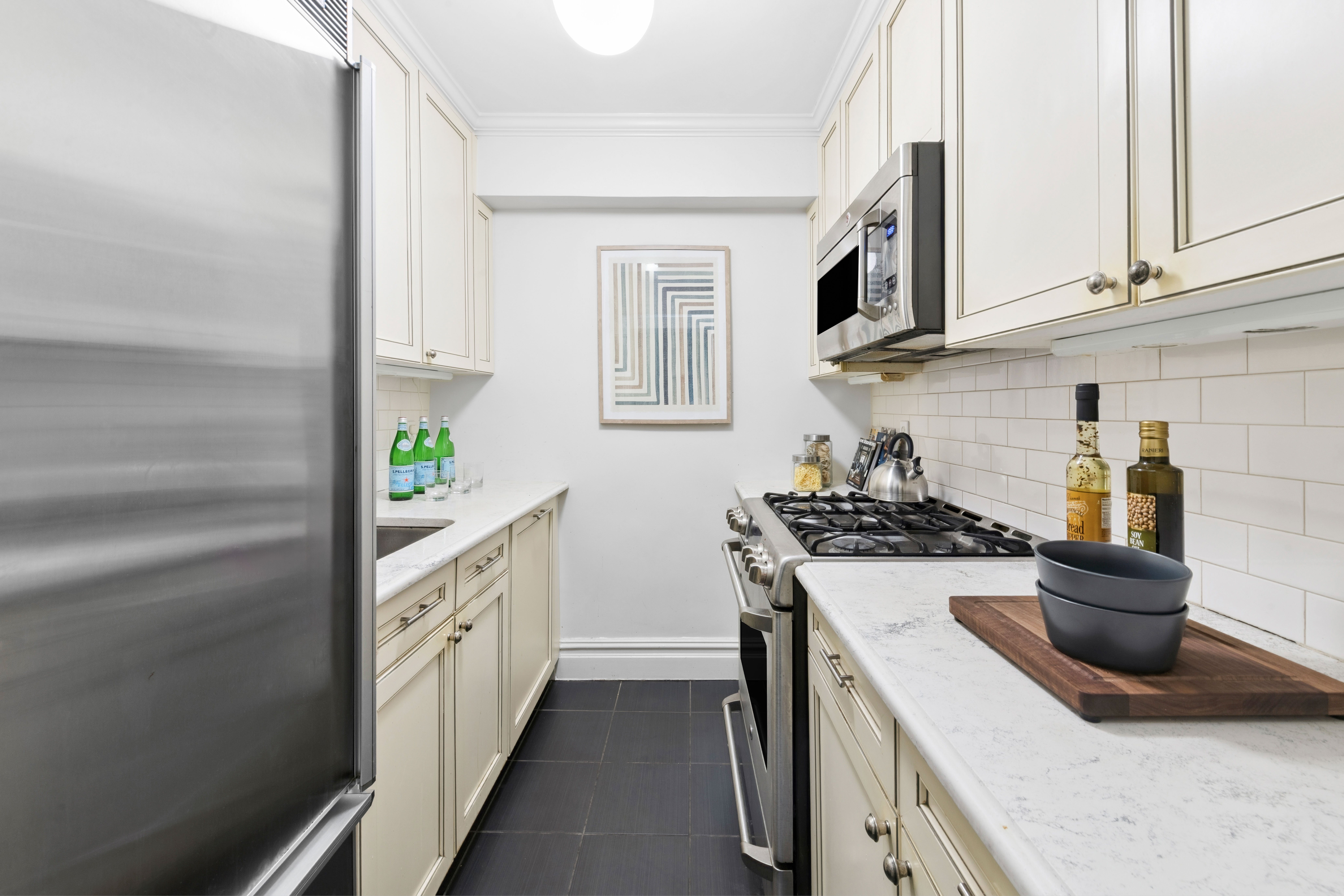 205 East 77th Street, Unit 3A Manhattan, NY 10075 - Photo 3 of 9 a kitchen with stainless steel appliances granite countertop a sink and a stove