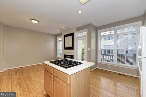a view of kitchen island with wooden floor and appliances