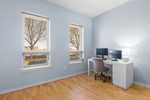 a view of a workspace with furniture and a window