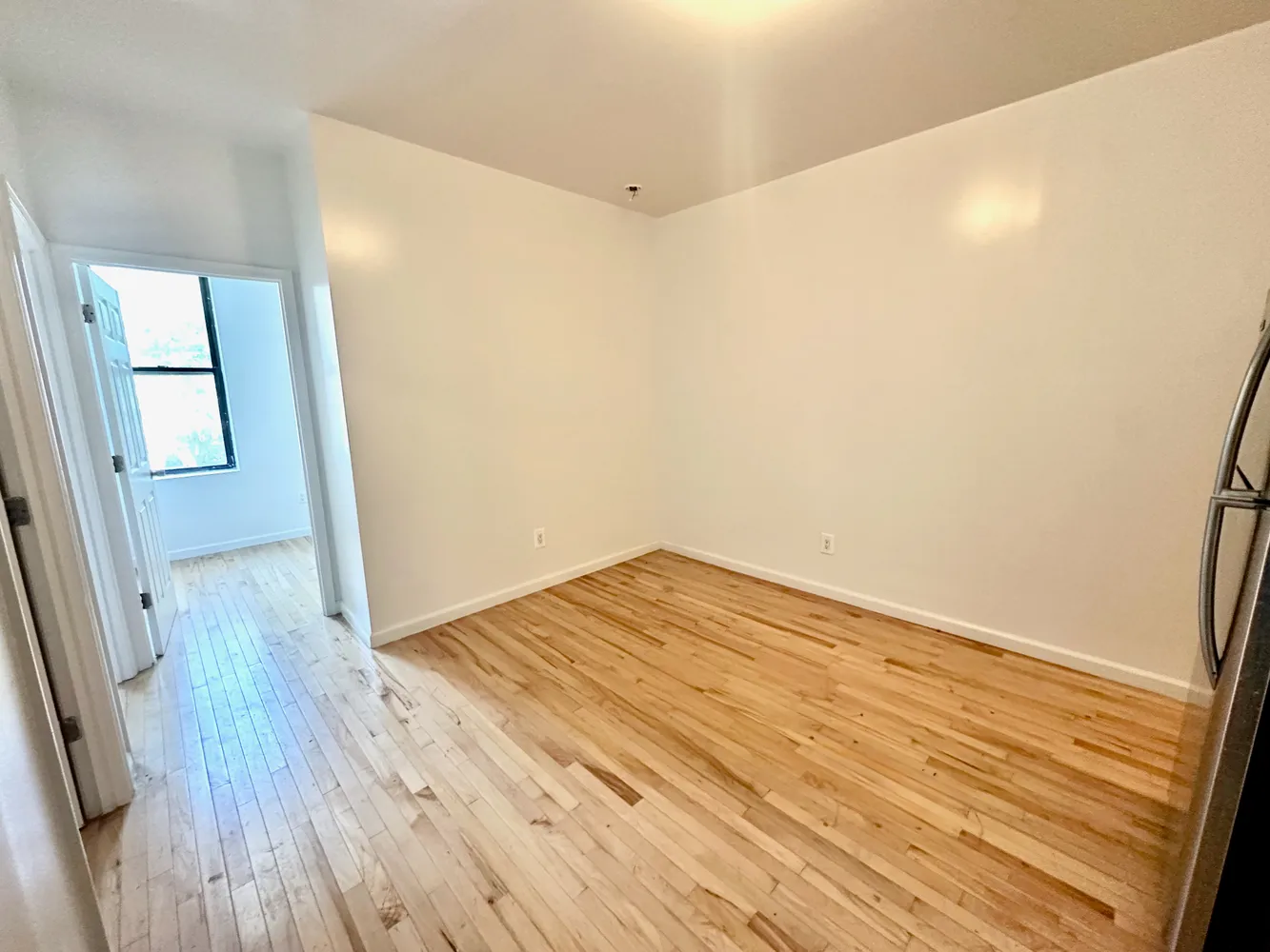a view of empty room with wooden floor