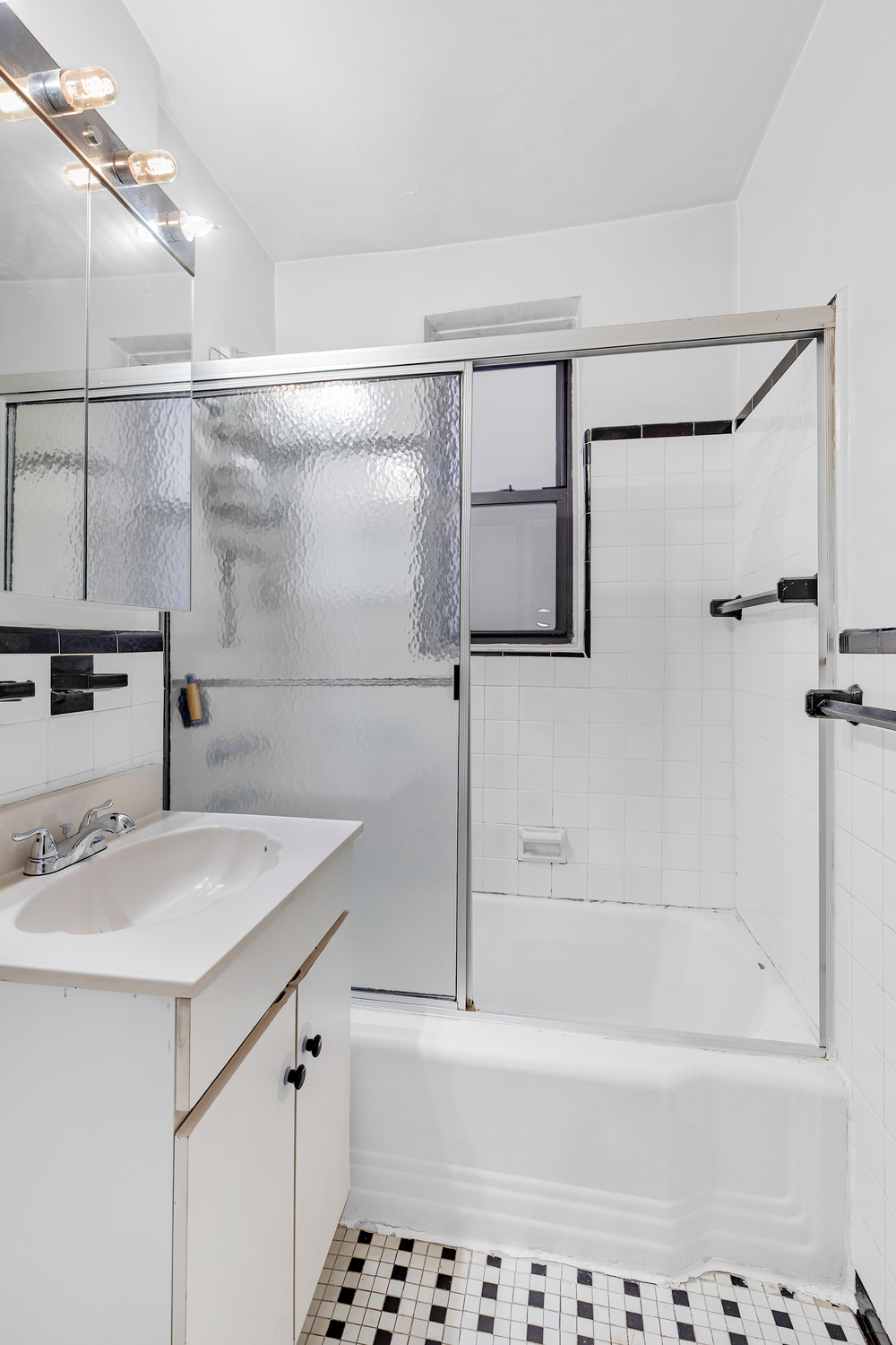50-54 East 8th Street, Unit 3S Manhattan, NY 10003 - Photo 6 of 7 a bathroom with a sink a mirror and a bathtub