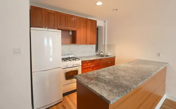 a kitchen with granite countertop a refrigerator and a sink