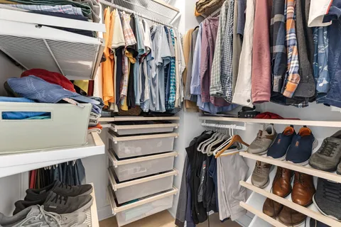 a view of walk in closet with clothes and shoes