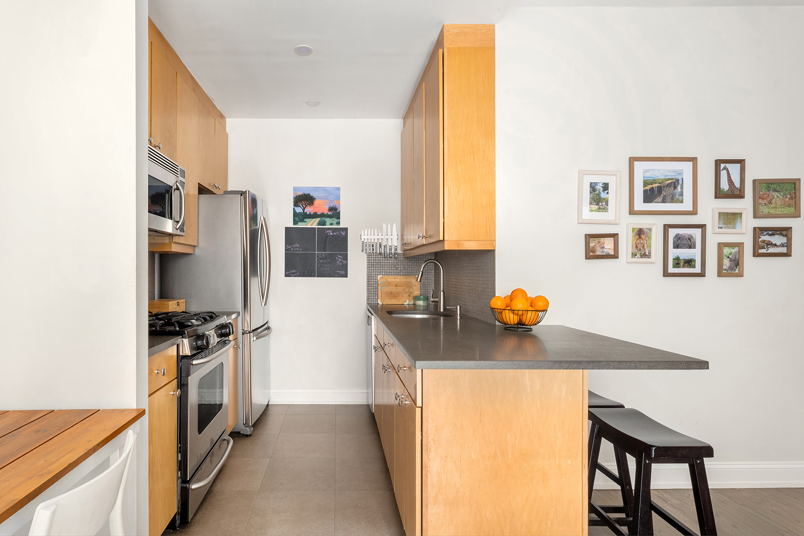 304 West 88th Street, Unit GC Manhattan, NY 10024 - Photo 5 of 16 a kitchen with stainless steel appliances a stove a refrigerator a sink a counter space and cabinets