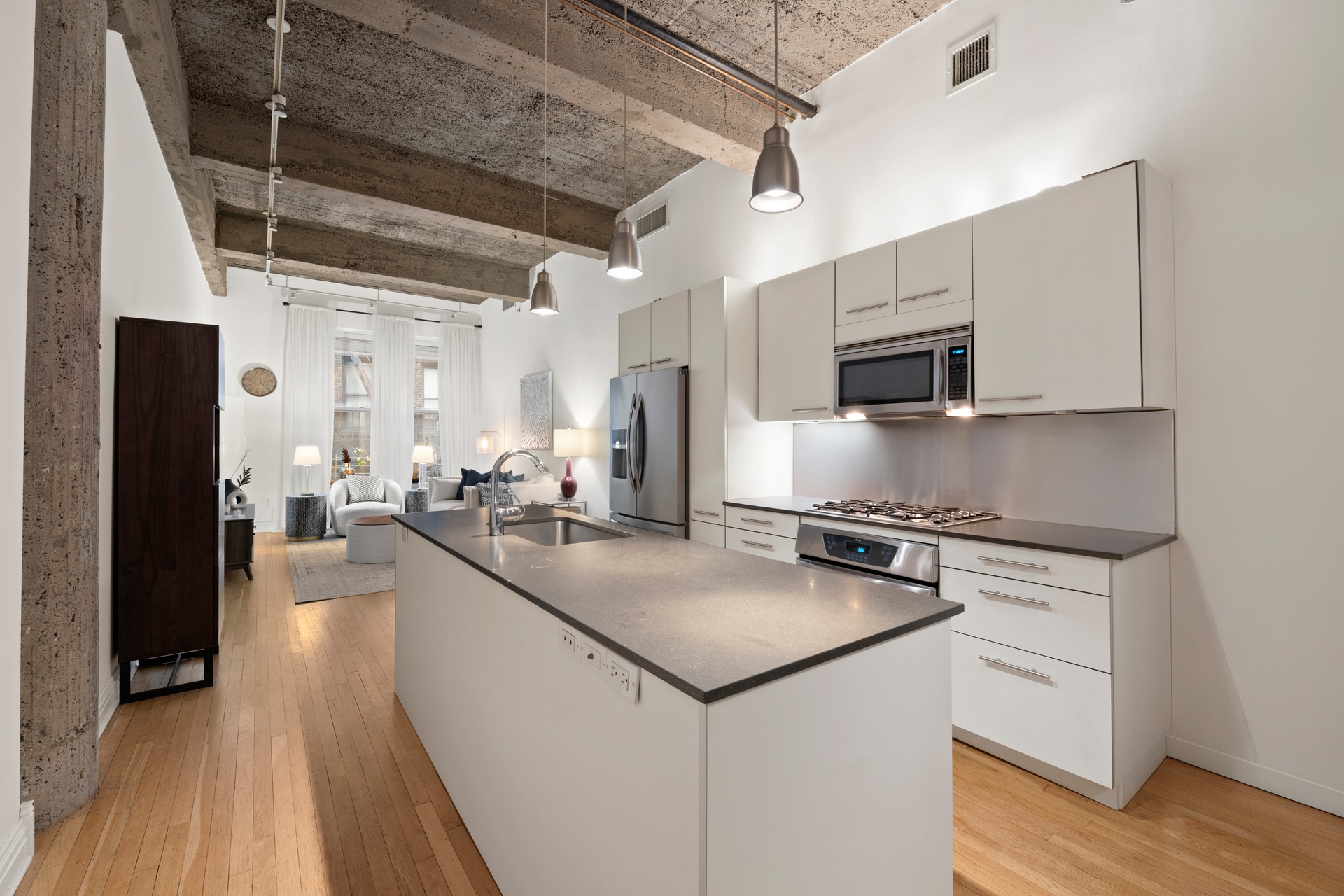 419 West 55th Street, Unit 2D Manhattan, NY 10019 - Photo 3 of 10 a kitchen with stainless steel appliances a sink dishwasher a stove top oven a refrigerator and cabinets with wooden floor