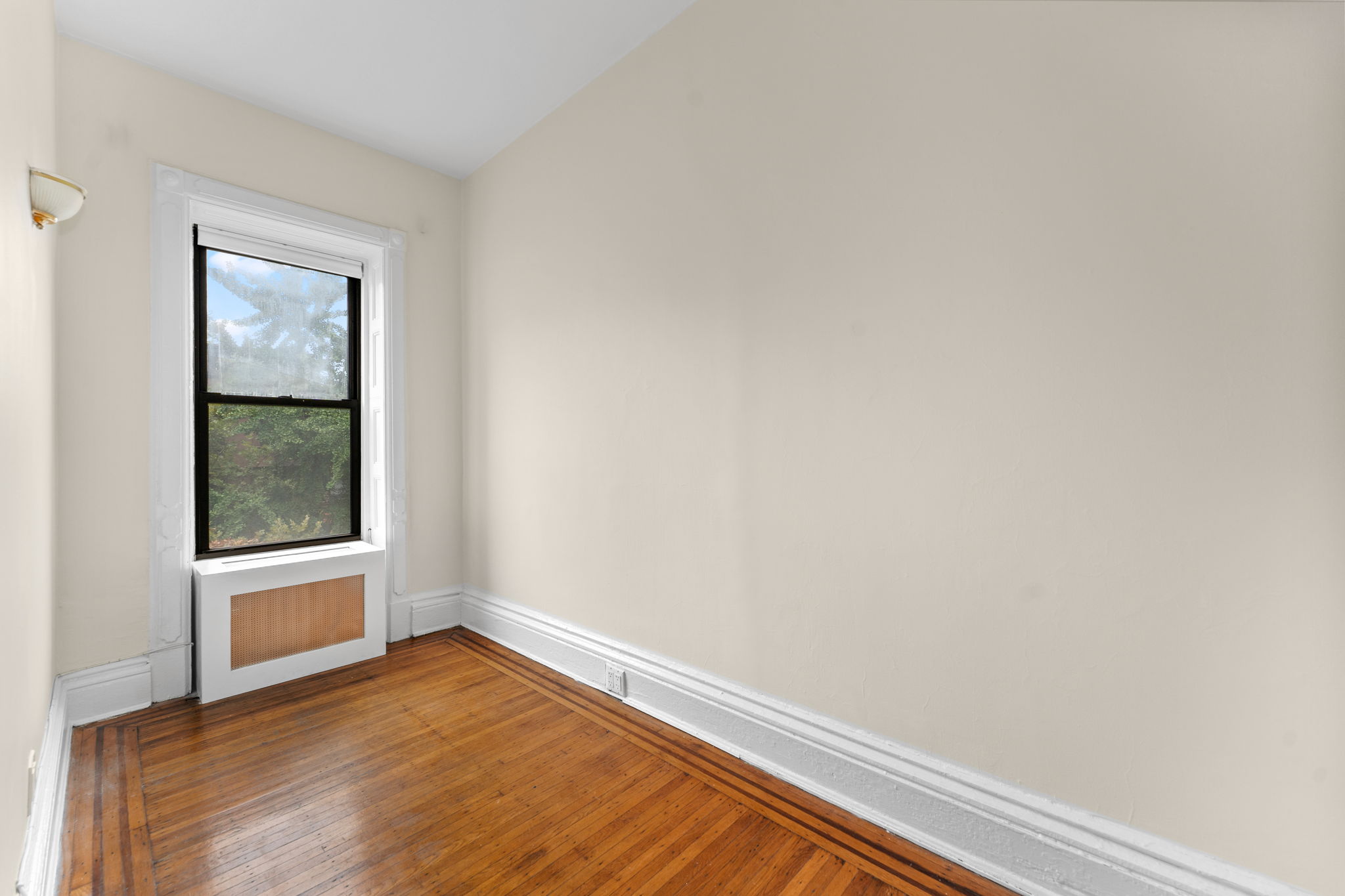 149 Sterling Place, Unit 4 Brooklyn, NY 11217 - Photo 5 of 9 a view of an empty room with wooden floor and a window
