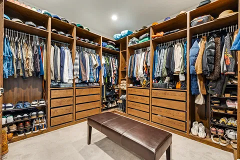 a view of walk in closet with clothes and shoes