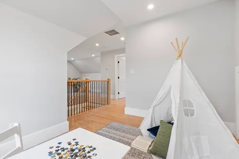 a view of a hallway with a white door and wooden floor