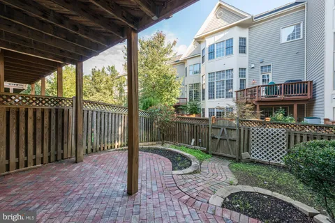 a view of a brick house with a small yard and wooden fence