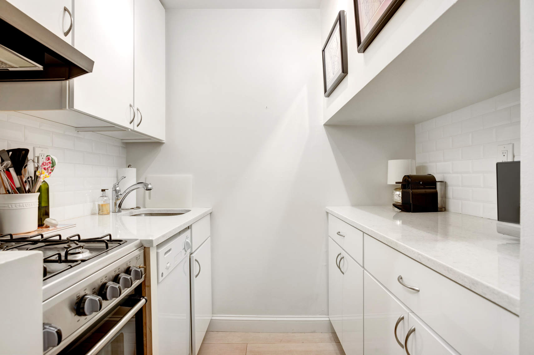 310 East 23rd Street, Unit 7C Manhattan, NY 10010 - Photo 9 of 18 a kitchen with stainless steel appliances white cabinets and a stove