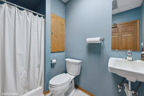 a bathroom with a toilet a sink and a mirror