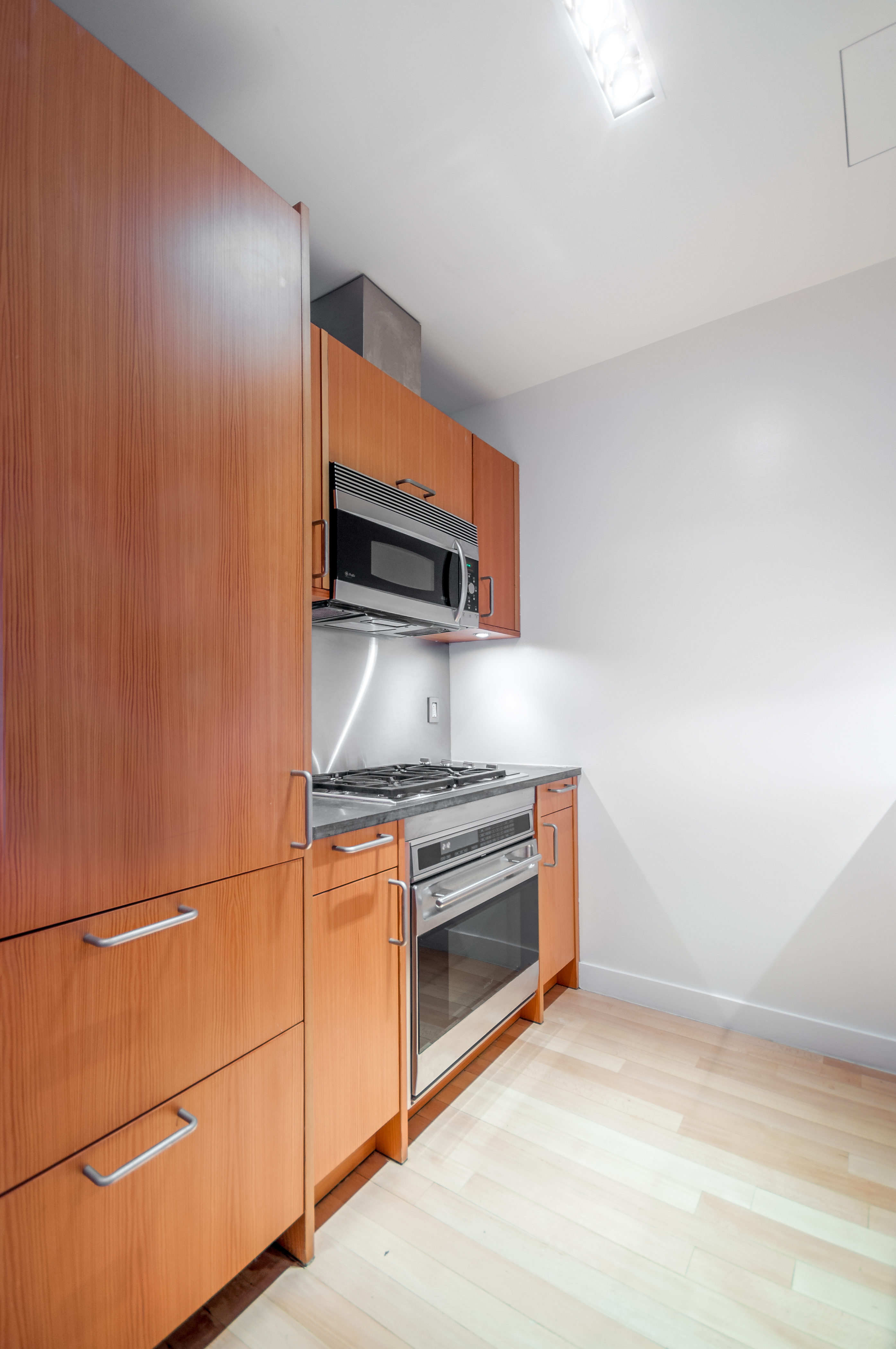450 East 83rd Street, Unit 3D Manhattan, NY 10028 - Photo 7 of 15 a kitchen with stainless steel appliances granite countertop a refrigerator and a stove top oven