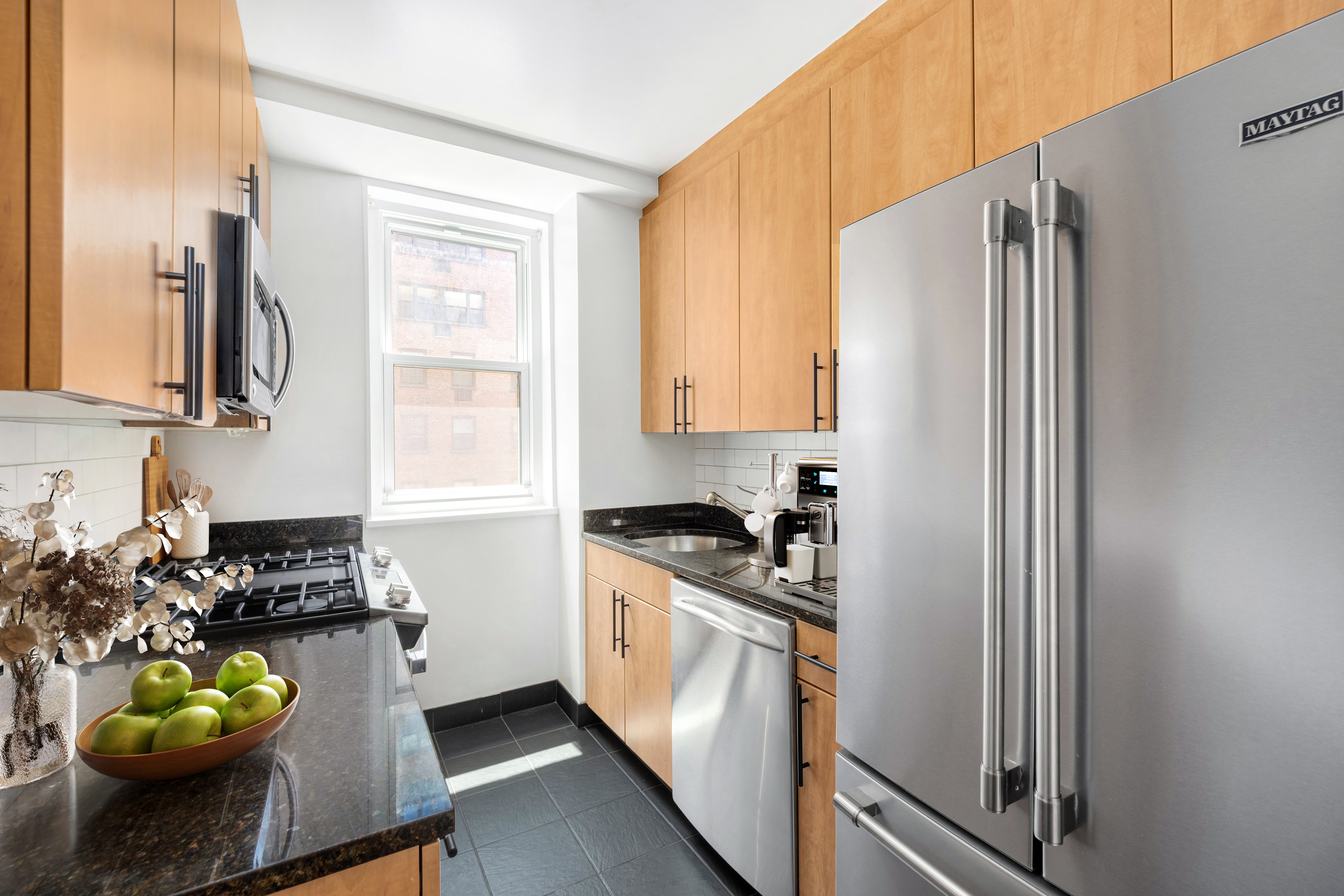 63 East 9th Street, Unit 6F Manhattan, NY 10003 - Photo 4 of 9 a kitchen with sink refrigerator and window