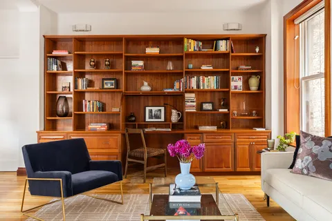 a living room with furniture and a book shelf