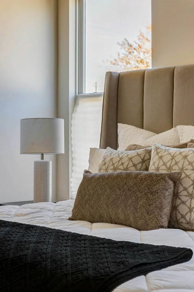 a large bed sitting in a bedroom next to a window