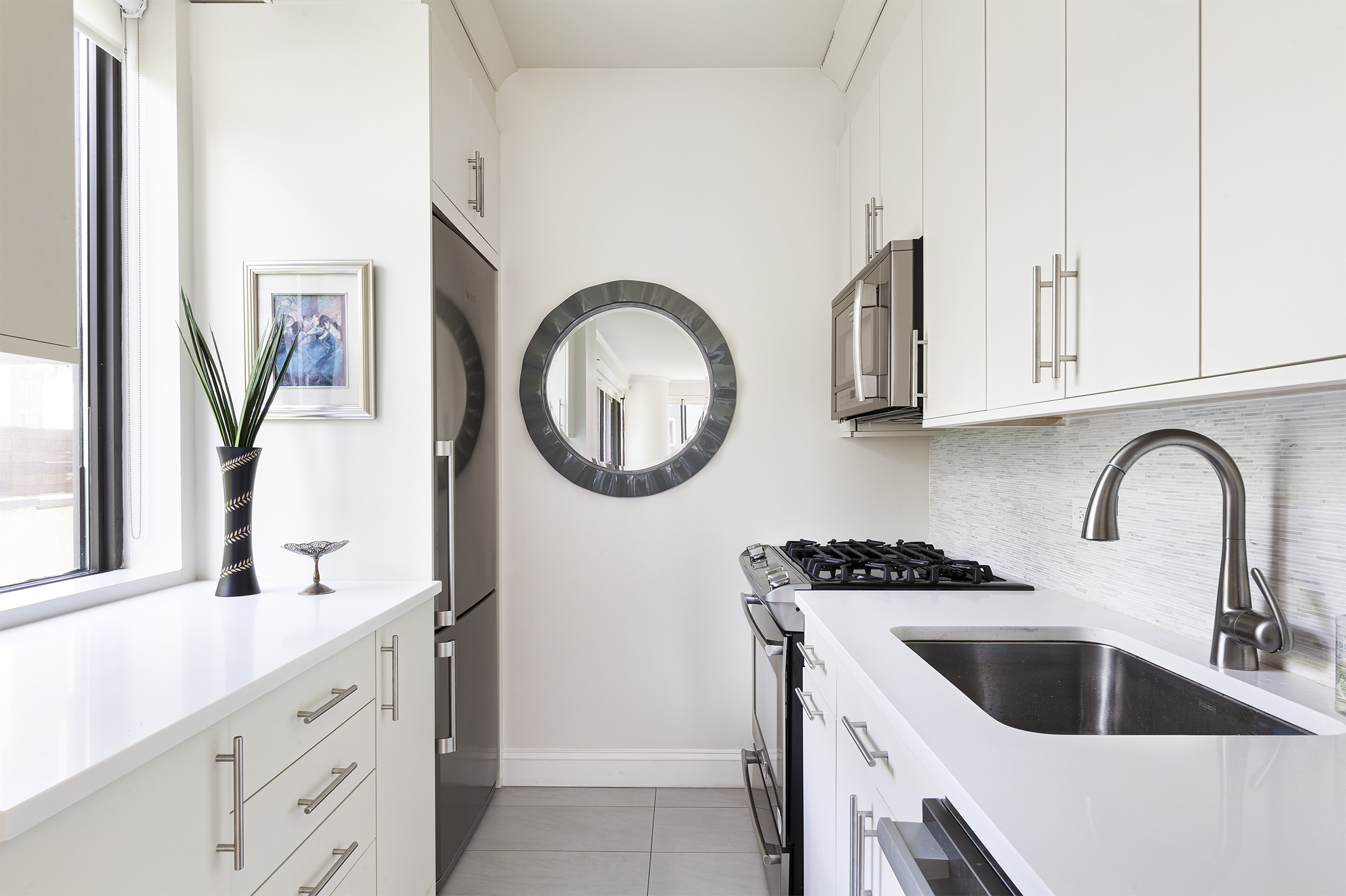 167 East 61st Street, Unit 7C Manhattan, NY 10065 - Photo 6 of 7 a kitchen with stainless steel appliances granite countertop a sink and a stove with wooden floor